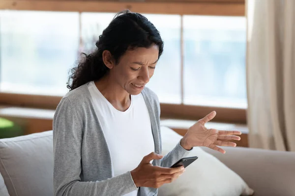 Angry biracial woman having problems with smartphone