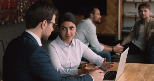 Indiska affärskvinna och kaukasisk affärsman använder laptop diskuterar nytt projekt — Stockvideo