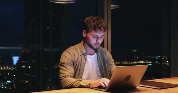 Employee sit at night in office working using laptop — Stockvideo