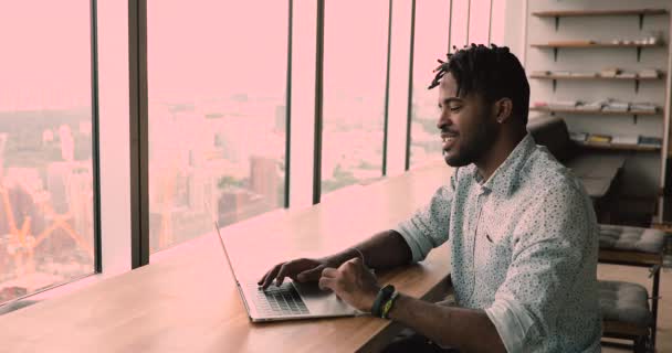 African employee working alone in coworking office using laptop — Vídeos de Stock