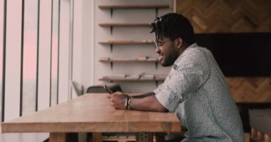 Afrikalı adam akıllı telefondan harika haberler okuyor.