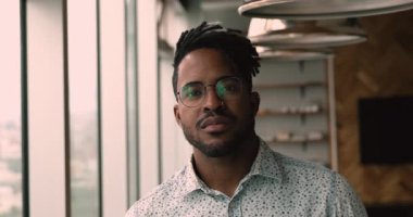 Rastalı şık Afrikalı adam içeride poz veriyor.