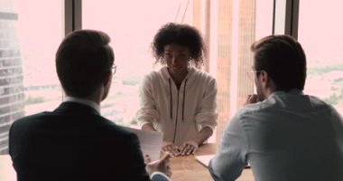 Arkadan erkek yöneticiler Afrikalı etnik kökenli kadın başvuru sahipleriyle görüşüyor.