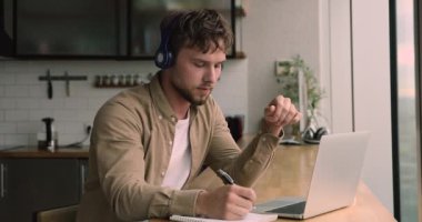 Kulaklık takan bir adam internet öğretmeniyle görüntülü konuşma yapıyor.