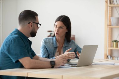 Ofis toplantısında dizüstü bilgisayarla beyin fırtınası yapan çalışanlar.