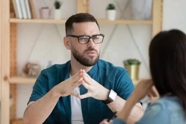 Descontento empleado masculino piensa hablar con colega en la reunión —  Fotos de Stock