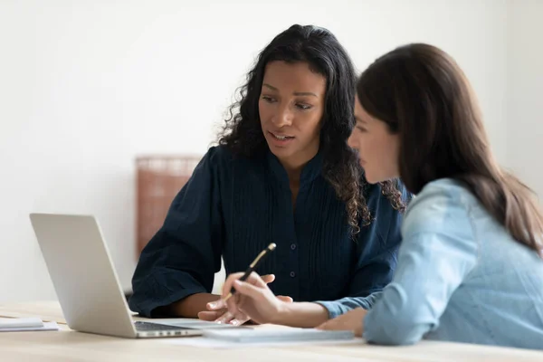 Multiracial female colleagues work on laptop in office — Stockfoto