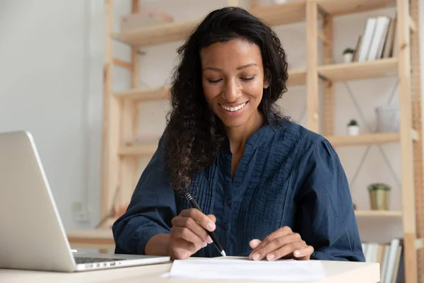 Smiling biracial woman work with paperwork in office