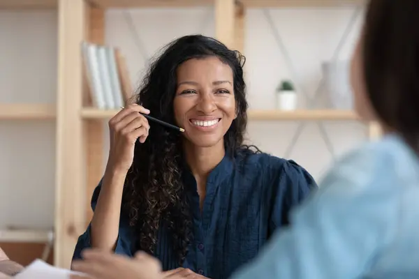 Smiling African American woman talk with colleague at meeting — Stockfoto