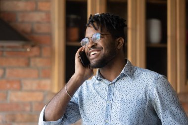 Mutlu, duygusal, Afro-Amerikan bir adam cep telefonuyla konuşuyor..