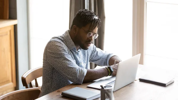 Focused young african american man watching educational webinar on laptop. — Stock Photo, Image