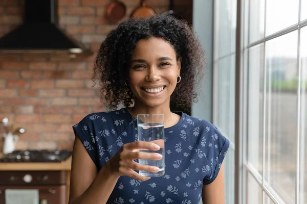 Щаслива молода багаторасова етнічна жінка тримає склянку води . — стокове фото