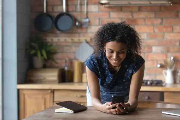 Dipendenti dalla tecnologia giovane signora birazziale utilizzando l'applicazione cellulare. — Foto Stock