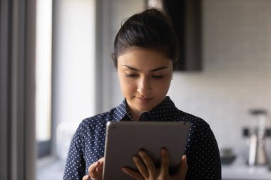 Konsantre Hindu kadın sosyal ağda elektronik tablet sohbeti kullanıyor