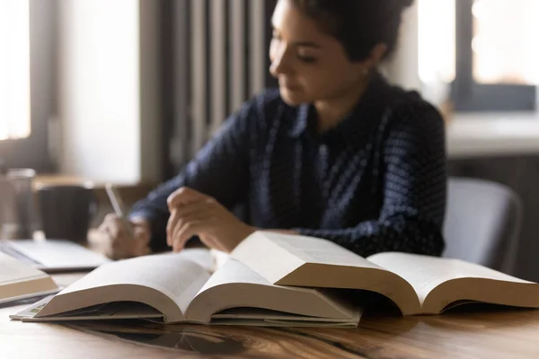 Ijverig duizendjarige indiase vrouwelijke student het nemen van notities uit papieren boeken — Stockfoto