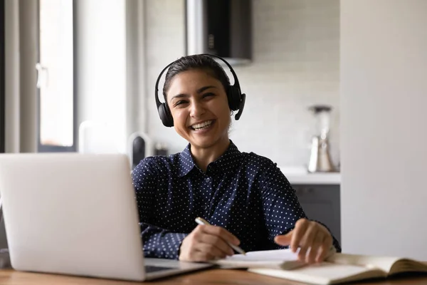 Cheerful millennial hindu female studying from home using laptop earphones — Stock Photo, Image