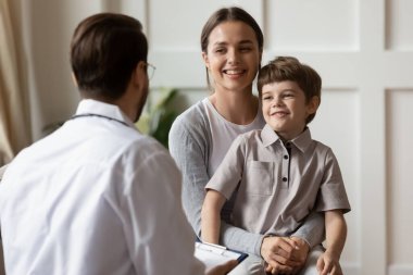 Hastanede konsültasyonda gülümseyen anne ve küçük oğlu.