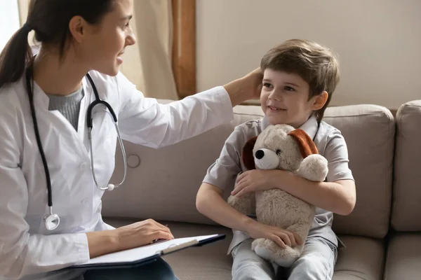 Vårdande kvinnlig läkare undersöka liten pojke patient på sjukhus — Stockfoto