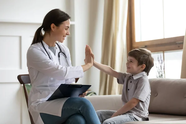 Gülümseyen kadın doktor hastanede küçük çocukla selamlaşıyor. — Stok fotoğraf