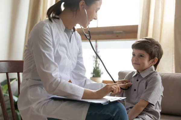 Verzorgende vrouwelijke kinderarts onderzoeken kleine jongen patiënt — Stockfoto