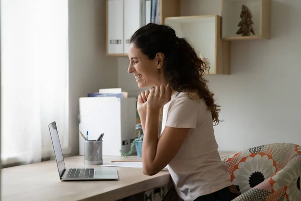 Overjoyed woman using laptop, chatting online, making video call