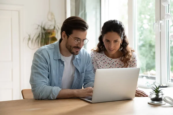 Jong gezin met laptop samen, zitten aan tafel in de keuken — Stockfoto