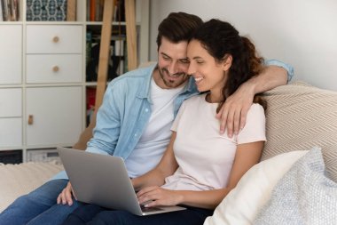 Mutlu karı koca kucaklaşması, evde dizüstü bilgisayar kullanması.