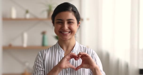 Headshot portret glimlachende Indiase vrouw tonen hart symbool met handen — Stockvideo