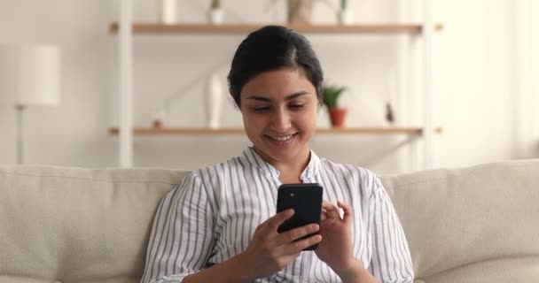 Indiska kvinna läsa sms på smartphone känns glad fira framgång — Stockvideo