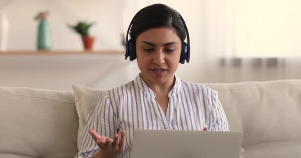 A fejhallgatós nő videokonferencia és laptop használatával beszél egy barátjával. — Stock videók