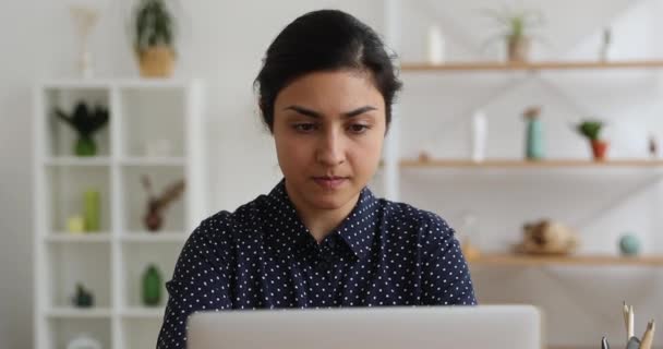 Ciddi düşünceli Hintli kadın dizüstü bilgisayar kullanarak çalışıyor. — Stok video