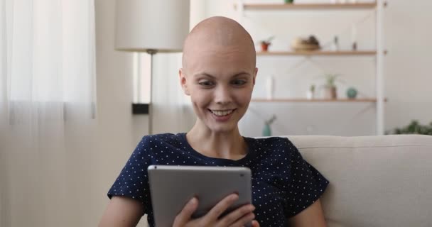 Sonriente mujer joven sin pelo celebración de videollamada con tableta. — Vídeos de Stock
