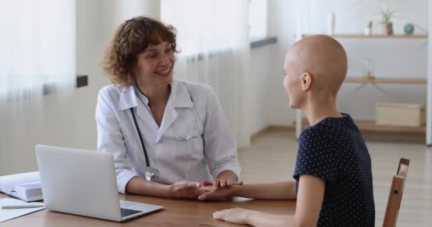 Příjemný lékař drží ruku usměvavé mladé ženy bez srsti pacienta. — Stock video