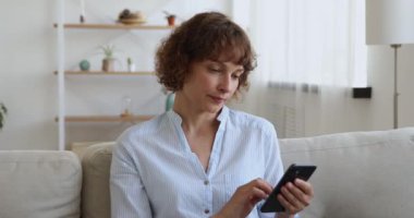 Cep telefonu uygulaması kullanan mutlu genç bir kadın..