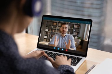 Bayan çalışanın arka planda iş arkadaşlarıyla görüntülü görüşme var