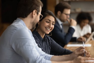 Gülümseyen çeşitli meslektaşlar iş yerinde birlikte çalışırlar