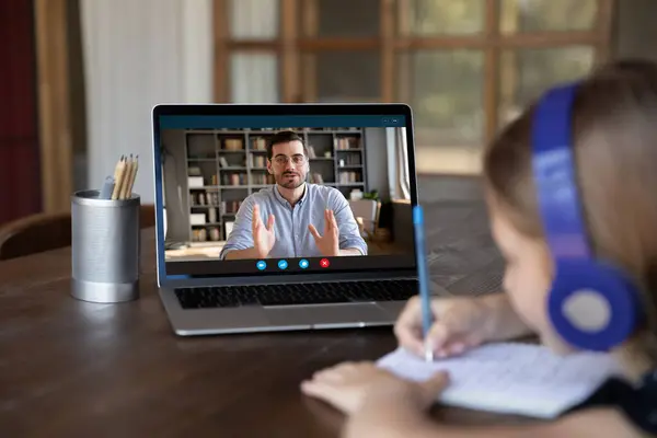 Close-up klein meisje dragen hoofdtelefoon studeren met leraar online — Stockfoto