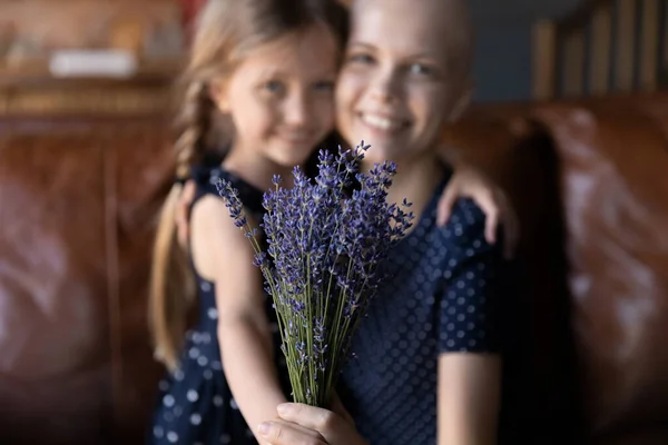 Närbild liten dotter presentera blommor till sjuk mor — Stockfoto