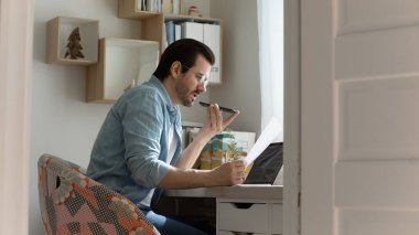 Gözlüklü, kendine güvenen, sesli mesaj kaydeden, elinde telefon tutan bir adam.