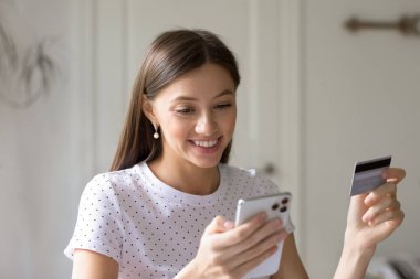 Elinde telefon ve kredi kartı olan, gülümseyen kadını kapat.