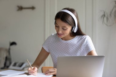 Kulaklık takarak, not yazarak, dizüstü bilgisayar kullanarak, internetten çalışarak.