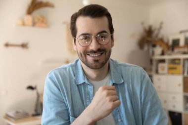 Gözlüklü, gülümseyen bir adamın portresi video çekiyor.