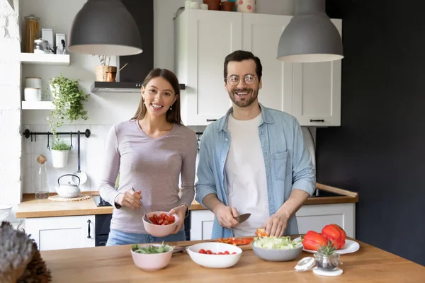 Gülümseyen kadın ve erkek portresi mutfakta birlikte yemek pişiriyorlar. — Stok fotoğraf