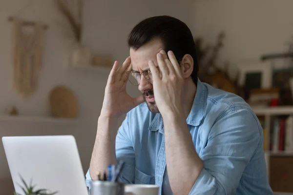 Un hombre insalubre con gafas que sufren de dolor de cabeza — Foto de Stock