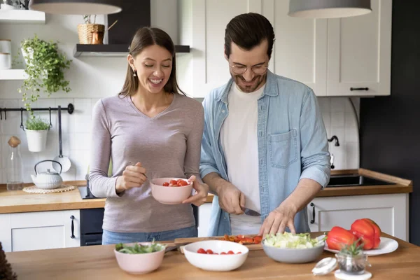 Mutlu genç çift birlikte salata pişiriyor, evde akşam yemeği hazırlıyor. — Stok fotoğraf