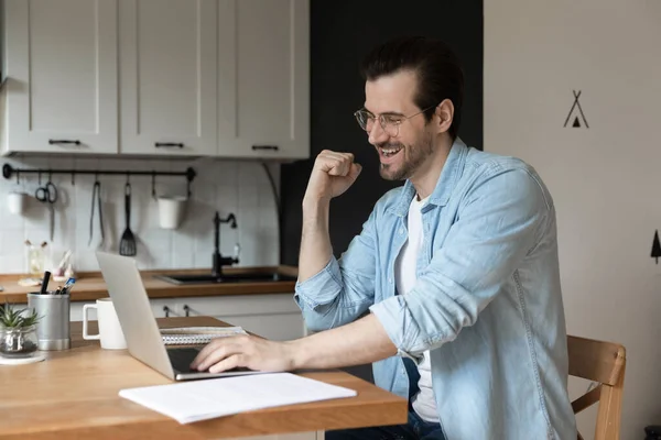 Щасливий чоловік носить окуляри за допомогою ноутбука, показуючи так жест — стокове фото
