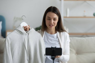 Gülümseyen genç bir kadının kıyafet inceleme videosunu çek.