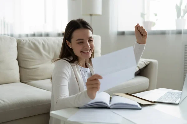 Возбужденная молодая женщина читает хорошие новости в бумажном письме — стоковое фото