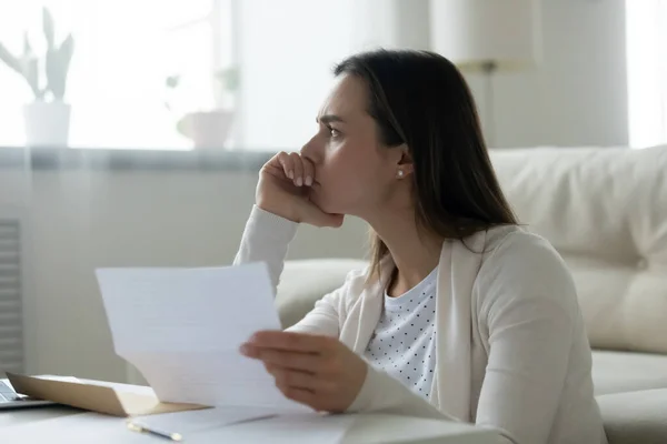 Primer plano pensativo frustrado joven mujer sosteniendo carta de papel — Foto de Stock