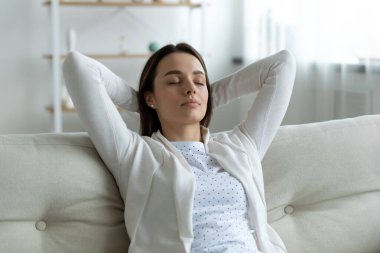 Ellerini başının arkasına koyup rahatlatan huzurlu genç bayanı kapat.